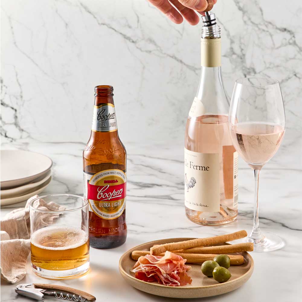 Wood Bottle Opener next to beer and Bottle Stopper into wine bottle - Robins Kitchen