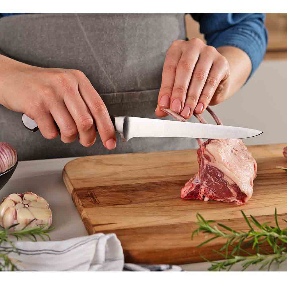 woman frenching rack of lamb with boning knife - Robins Kitchen