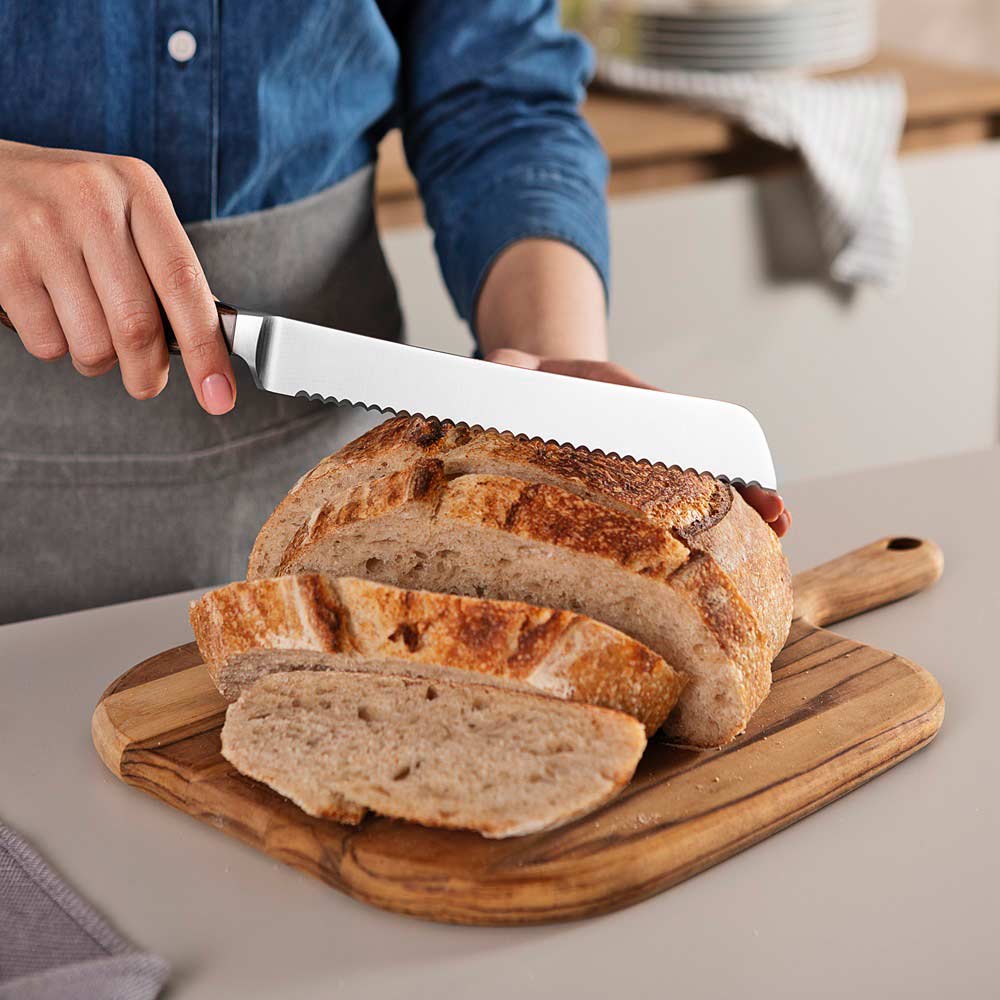 woman cutting slices of bread with bread knife at kitchen counter - Robins Kitchen