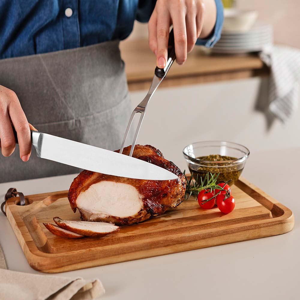 woman carving roast at kitchen bench with Utility Carving Knife - Robins Kitchen