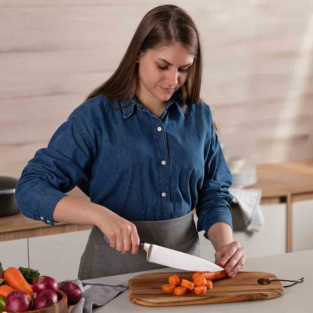 woman chopping carrot at kitchen counter with chef knife - Robins Kitchen