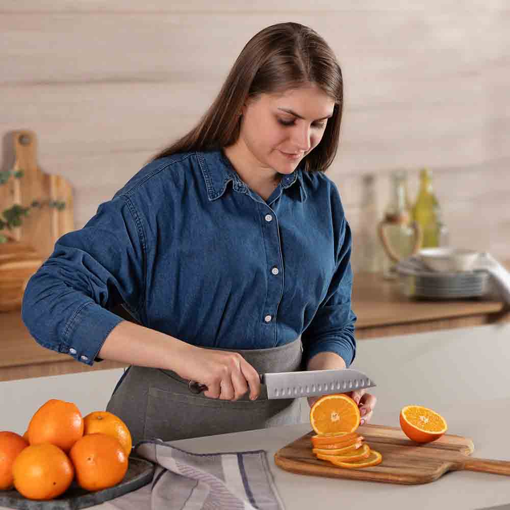 Woman slicing an orange with Santoku Knife 7 Inch - Robins Kitchen